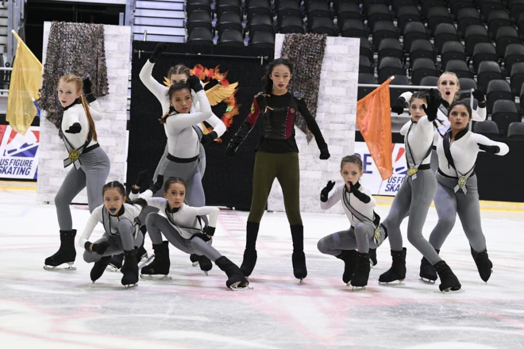 Novice Team on ice in champion and combat poses.